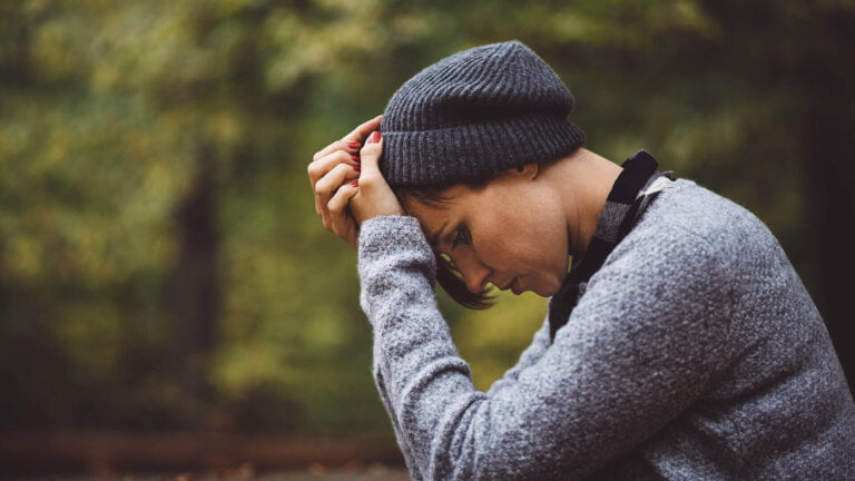 Exhausted woman holding her head in hands